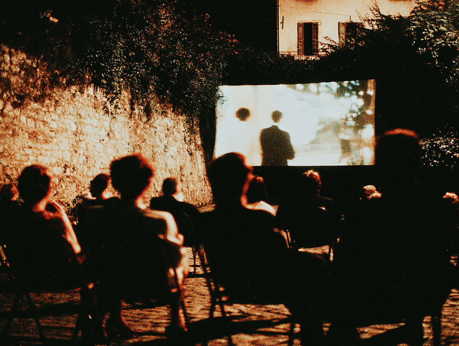 A diverse group of people from different generations enjoying a film together, illustrating 'Grease's' ability to captivate a wide audience.