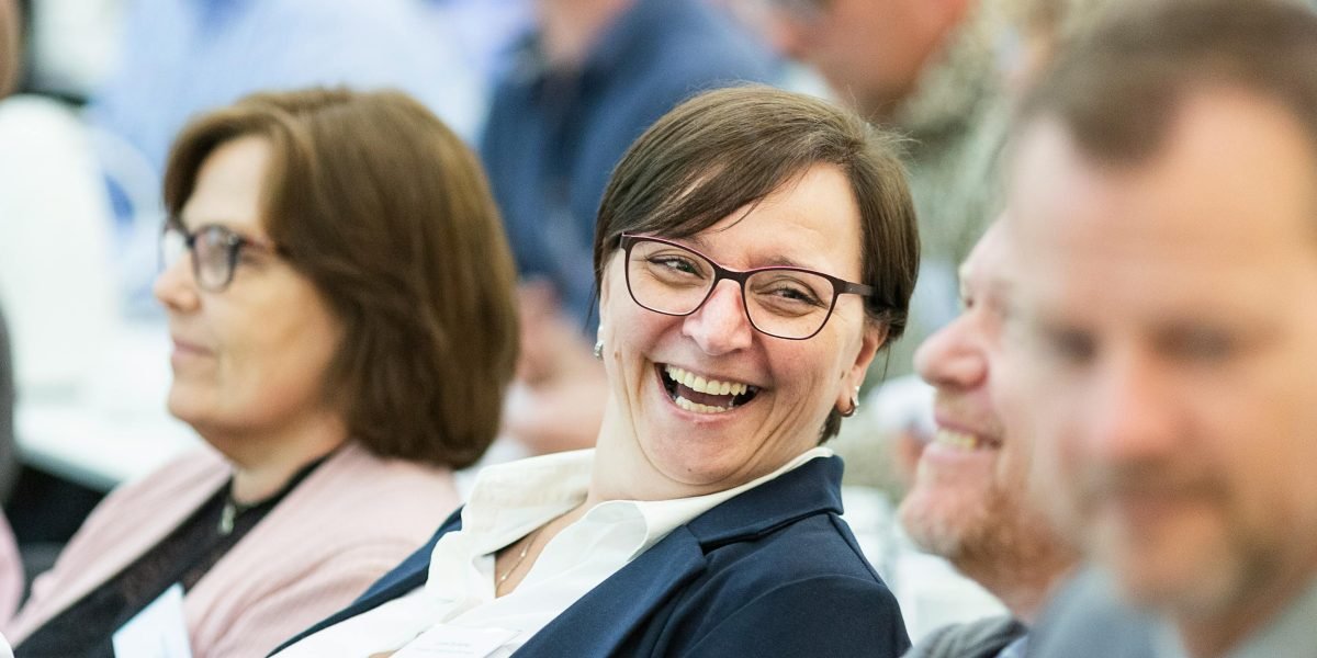 An audience caught in a moment of genuine laughter, showing the strong emotional connection humor can build.