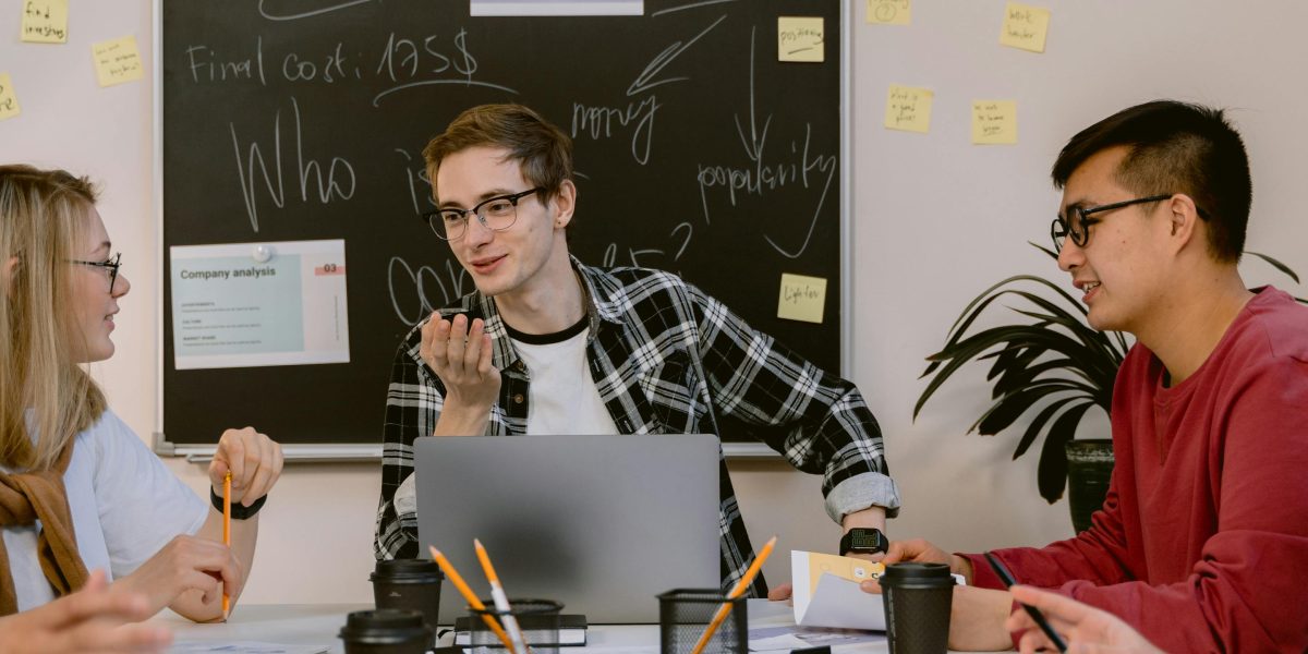 A team collaborates in a meeting, discussing creative strategies for developing unique content and humor.