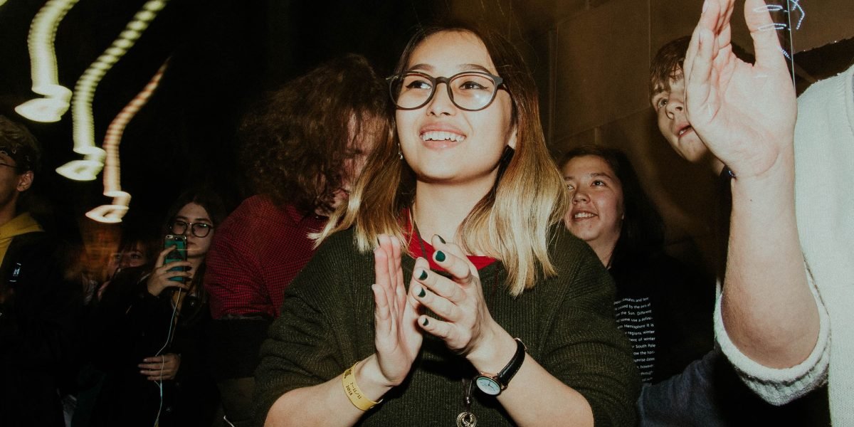 An energetic audience at a comedy show, captured in a moment of genuine laughter.