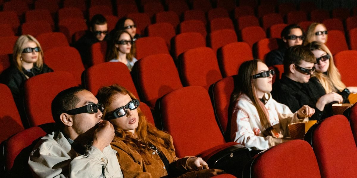 An audience enthusiastically cheering, symbolizing successful commercial and critical reception for a film.